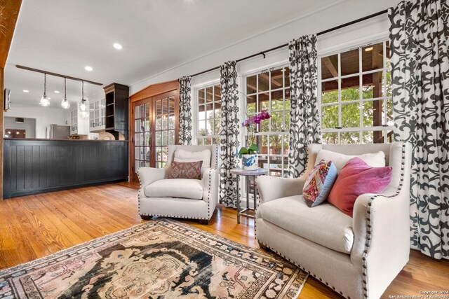 kitchen featuring light wood-type flooring, stainless steel appliances, white cabinets, and beamed ceiling