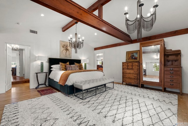 bedroom featuring lofted ceiling with beams, an inviting chandelier, and light hardwood / wood-style flooring