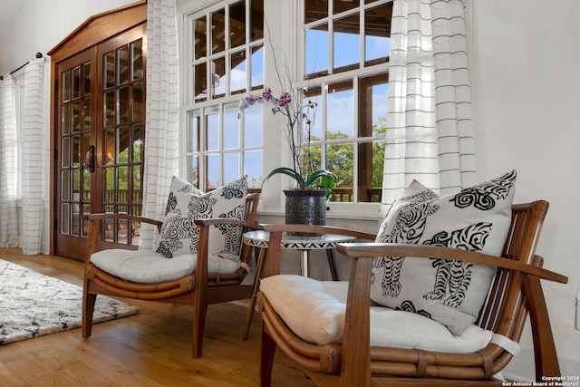 living area featuring a high ceiling and hardwood / wood-style floors