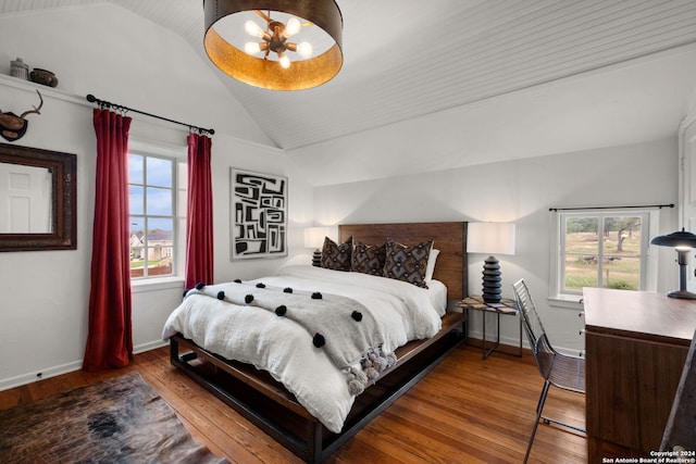 bedroom featuring lofted ceiling, a chandelier, and hardwood / wood-style floors