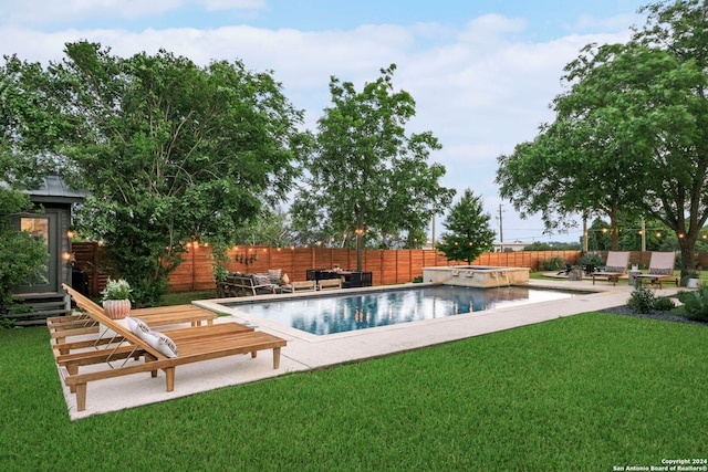 view of swimming pool with a patio, a yard, and an in ground hot tub