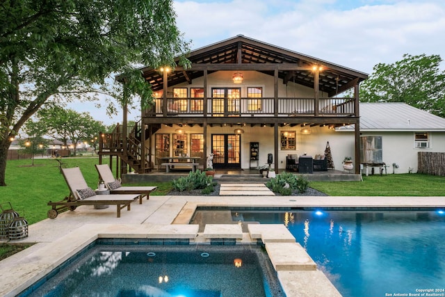 rear view of property with a swimming pool side deck, a yard, and a patio