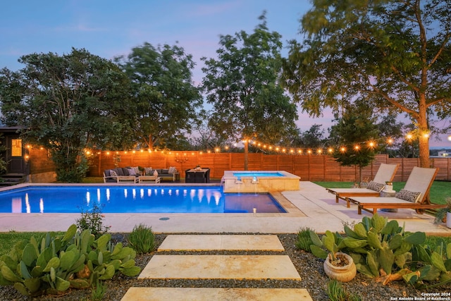 pool at dusk featuring an outdoor living space, a patio area, and an in ground hot tub