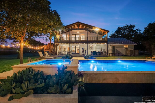 view of swimming pool featuring a lawn, a fire pit, a patio, and an in ground hot tub