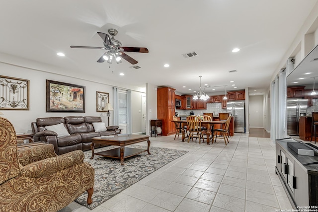 living room featuring ceiling fan with notable chandelier