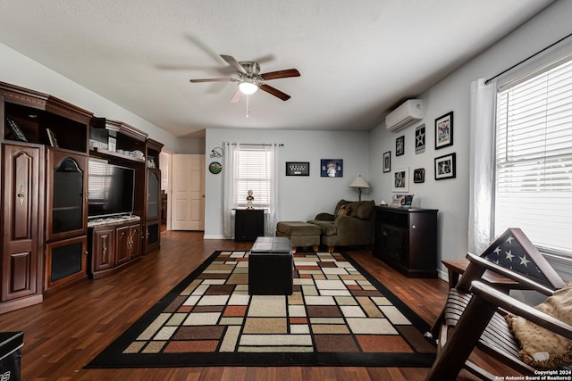 living room with ceiling fan, a wall mounted air conditioner, and dark hardwood / wood-style flooring