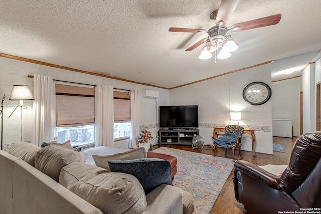 living room with ceiling fan, ornamental molding, wood-type flooring, and a textured ceiling