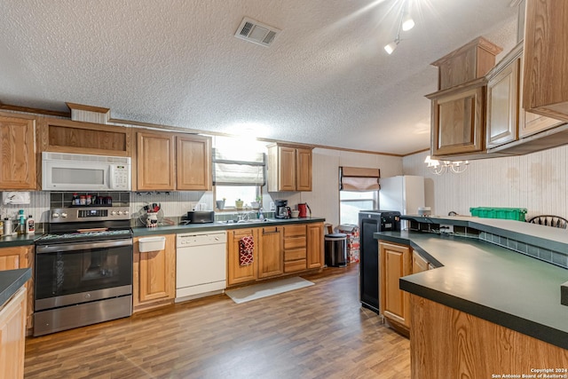 kitchen with hardwood / wood-style floors, sink, white appliances, crown molding, and a textured ceiling