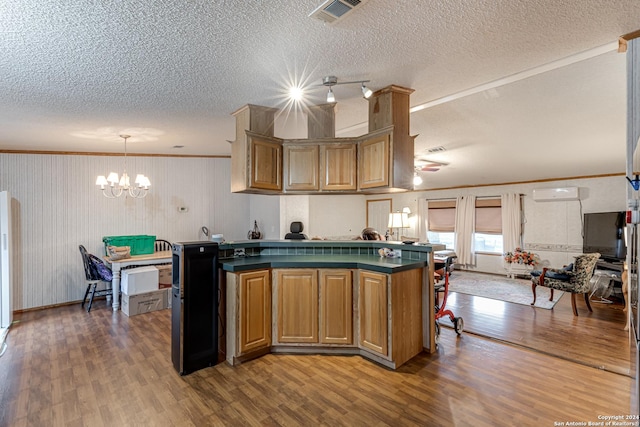 kitchen featuring dark wood-type flooring, a wall mounted AC, and a notable chandelier