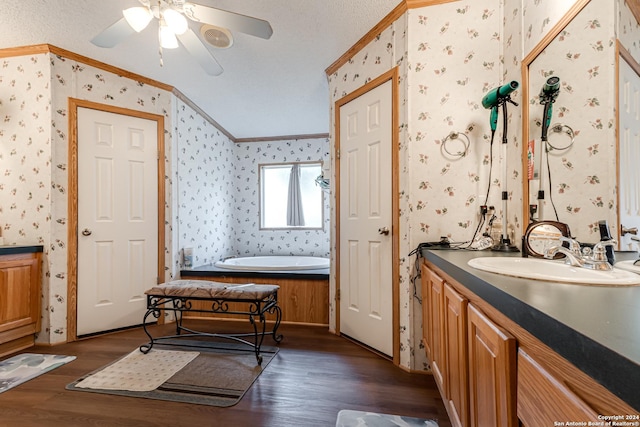 bathroom featuring hardwood / wood-style flooring, crown molding, vanity, and a tub to relax in