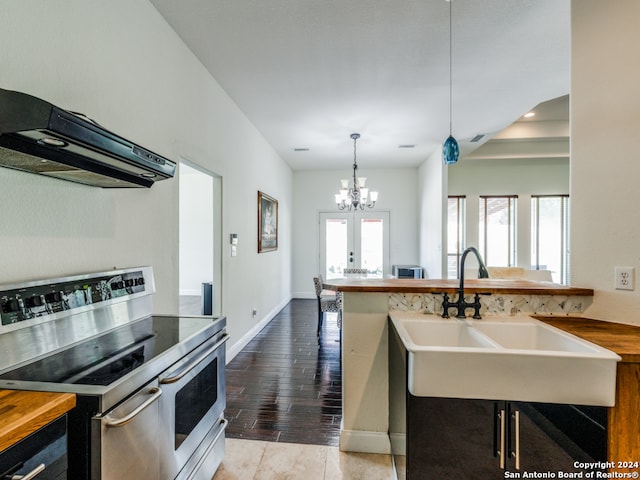 kitchen featuring extractor fan, an inviting chandelier, a healthy amount of sunlight, electric range, and wood-type flooring