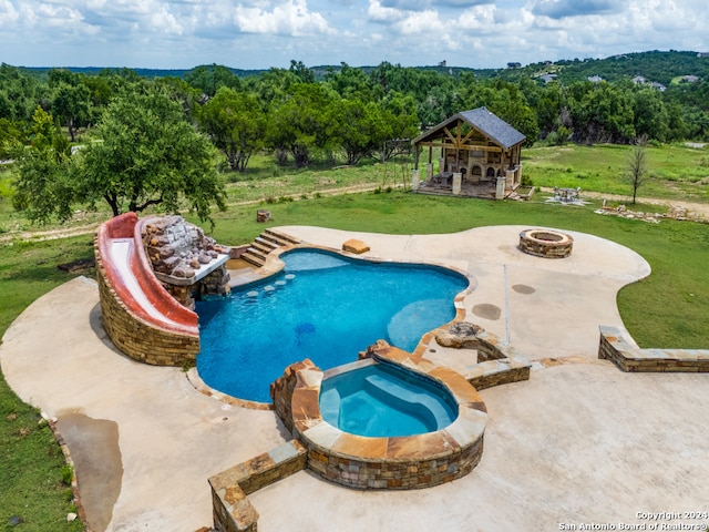 view of swimming pool with a yard, an in ground hot tub, a fire pit, a gazebo, and a patio