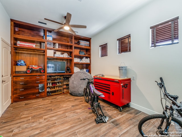 workout room with light hardwood / wood-style flooring and ceiling fan