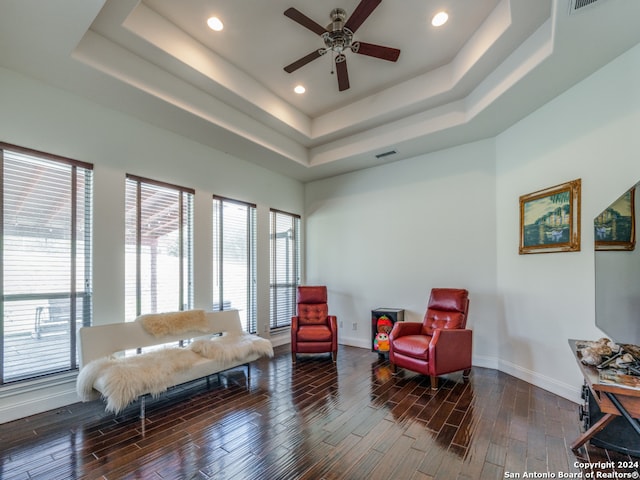 sitting room with a raised ceiling, hardwood / wood-style floors, and ceiling fan