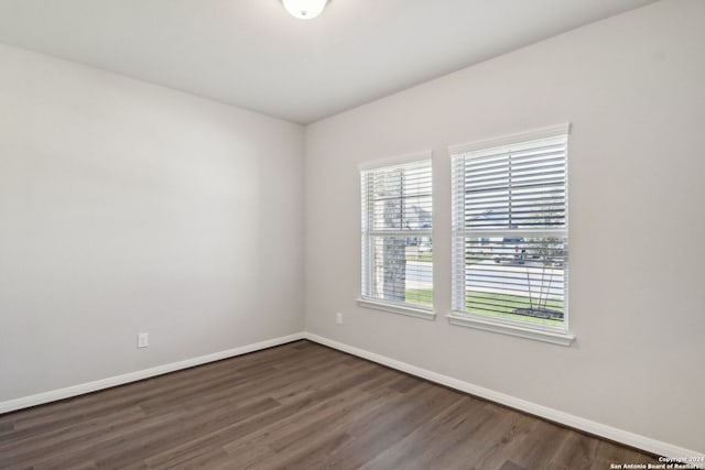 unfurnished room with dark hardwood / wood-style flooring