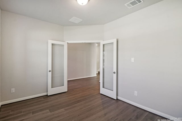 spare room with french doors and dark hardwood / wood-style floors