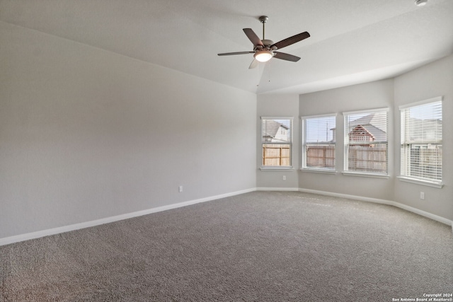 empty room featuring vaulted ceiling, carpet, and ceiling fan