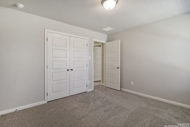 unfurnished bedroom with carpet floors and a closet