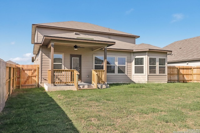 rear view of property with a yard and ceiling fan