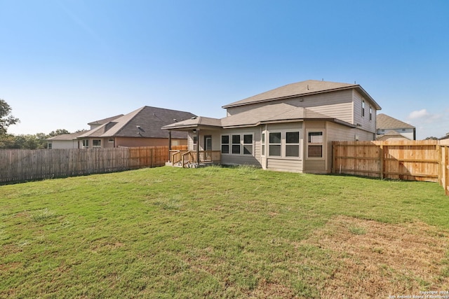 rear view of property with a lawn