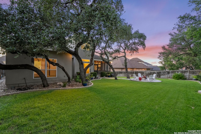 yard at dusk featuring a patio