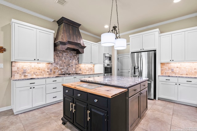 kitchen with custom range hood, a center island, backsplash, appliances with stainless steel finishes, and pendant lighting