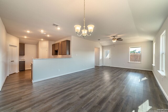 unfurnished living room with dark hardwood / wood-style floors and ceiling fan with notable chandelier