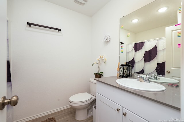 bathroom featuring toilet, hardwood / wood-style floors, and vanity