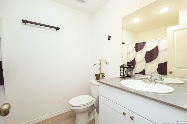 bathroom with hardwood / wood-style floors, toilet, and vanity