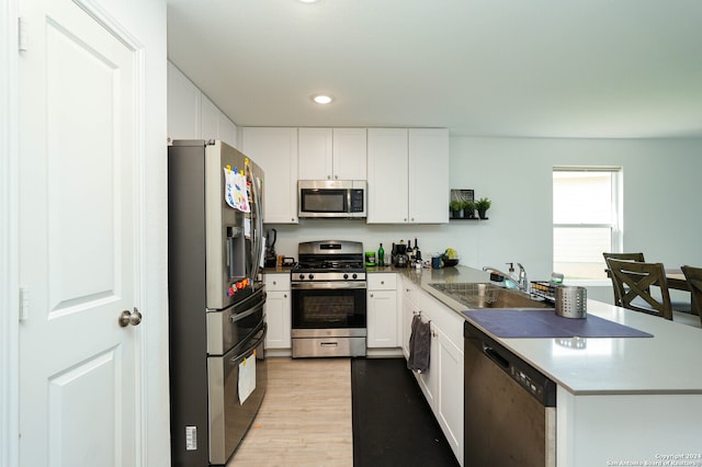 kitchen featuring sink, appliances with stainless steel finishes, white cabinetry, and light wood-type flooring