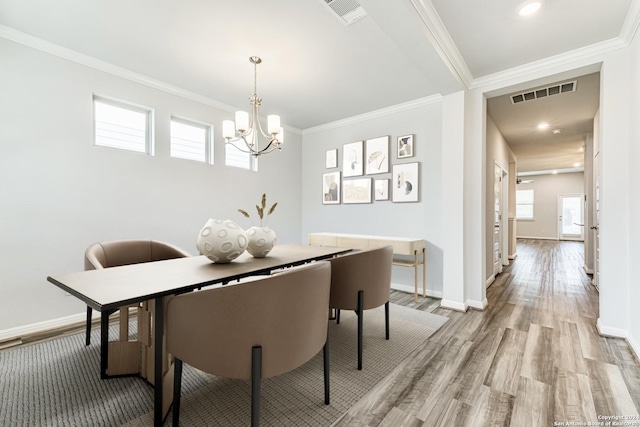 dining room featuring crown molding, a notable chandelier, and light hardwood / wood-style floors