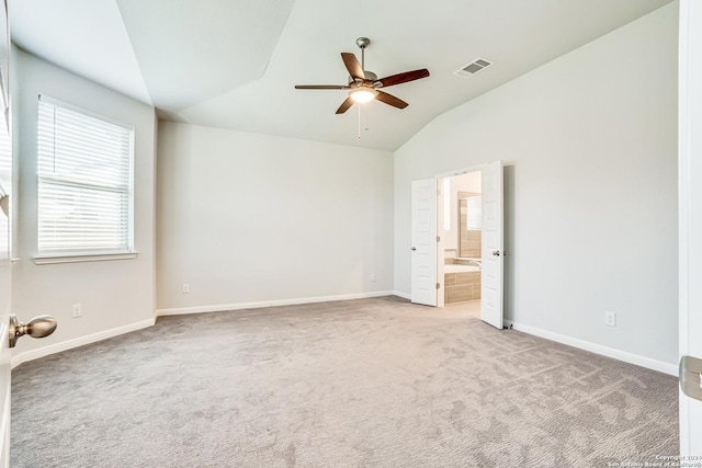 unfurnished bedroom featuring lofted ceiling, light carpet, ceiling fan, and ensuite bath