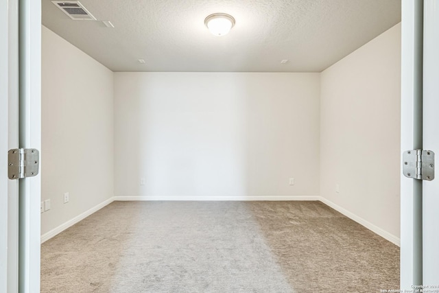 empty room featuring carpet and a textured ceiling