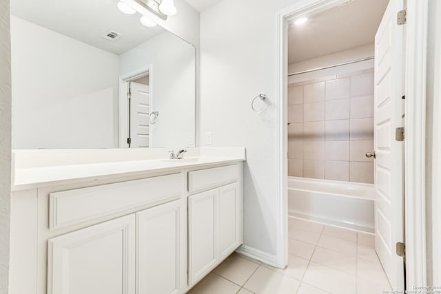 bathroom with tile patterned flooring, vanity, and tiled shower / bath combo