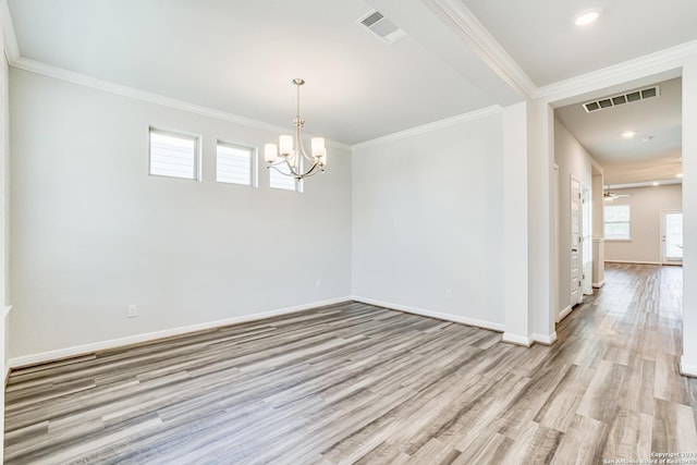 empty room with crown molding, an inviting chandelier, and light wood-type flooring