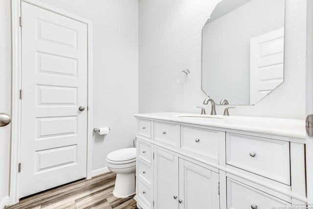 bathroom featuring hardwood / wood-style flooring, vanity, and toilet