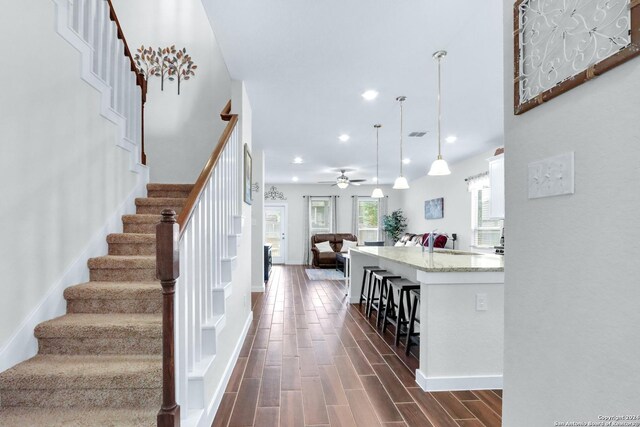 stairway featuring ceiling fan and wood-type flooring