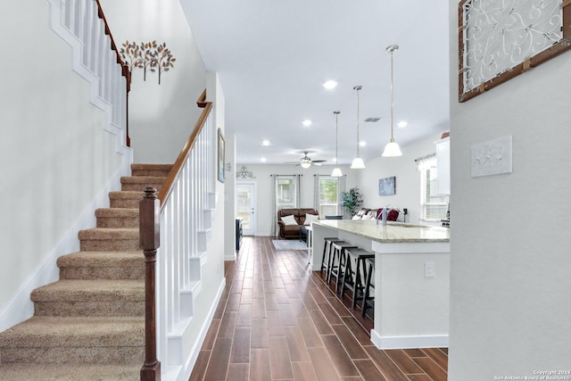 stairs featuring ceiling fan and sink