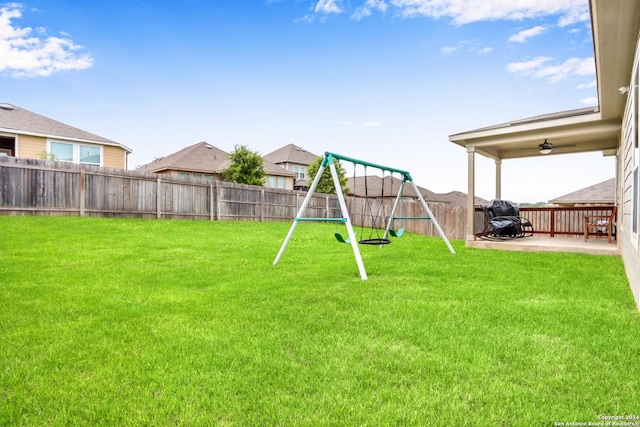 view of yard featuring a playground, ceiling fan, and a patio area