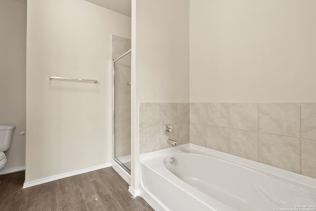 bathroom with toilet, hardwood / wood-style flooring, and shower with separate bathtub