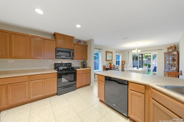 kitchen featuring black appliances, hanging light fixtures, light tile patterned floors, and an inviting chandelier