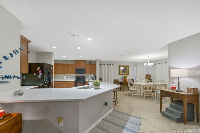 kitchen featuring light tile patterned flooring, sink, decorative light fixtures, kitchen peninsula, and black appliances