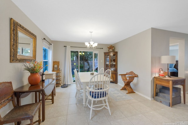 dining area with light tile patterned floors and a chandelier