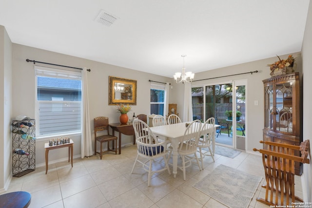 dining room with plenty of natural light, light tile patterned floors, and an inviting chandelier