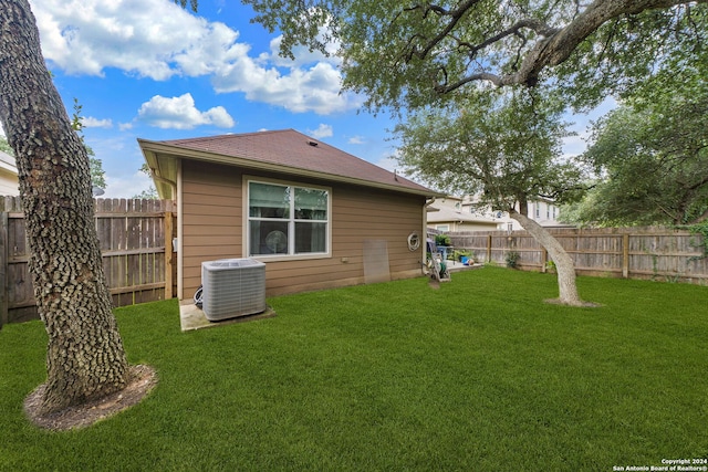 back of property featuring central AC and a lawn