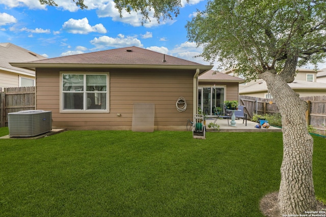 back of property featuring central AC, a lawn, and a patio area