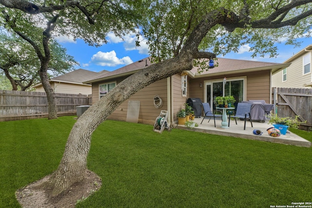 back of house with a yard and a patio area