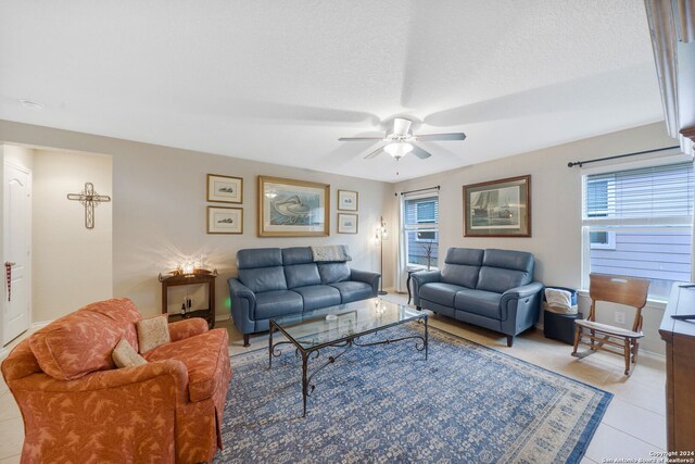 tiled living room with a textured ceiling, ceiling fan, and a wealth of natural light