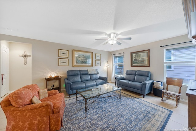 living room with ceiling fan, a textured ceiling, and light tile patterned floors