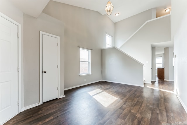 additional living space featuring dark hardwood / wood-style floors and a high ceiling